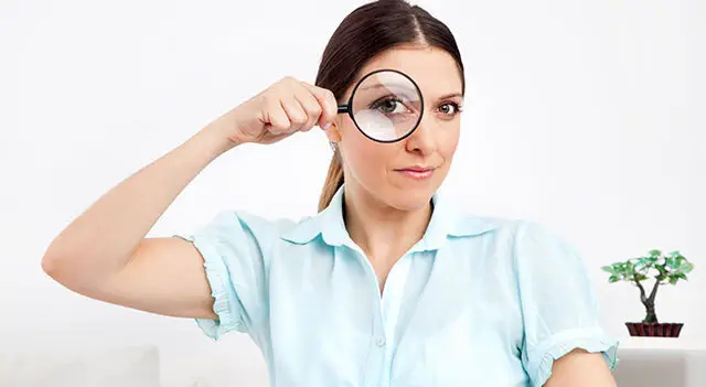 person looking through magnifying glass