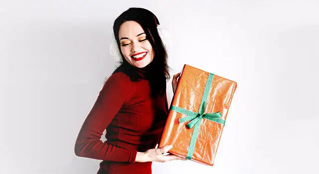 woman in holiday dress with gift